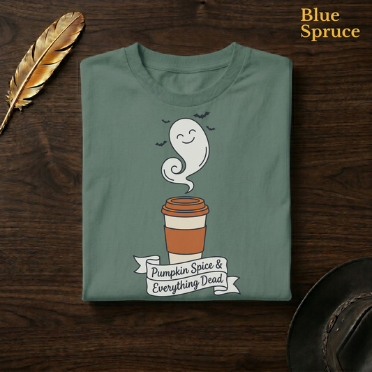 Cozy halloween shirt in Blue Spruce, a deep teal-green garment-dyed shirt folded flat on dark walnut wood beside a gold feather and a leather hat, the ghost latte and banner design on the chest, labelled Blue Spruce.