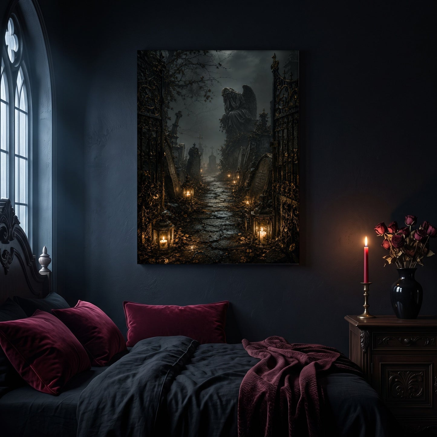 The Lychgate cemetery canvas hanging on a dark navy wall in a gothic bedroom, above a bed with burgundy velvet pillows and charcoal bedding, beside an arched leaded window and a wooden nightstand holding a lit red taper candle in a brass holder and a black vase of dried roses.