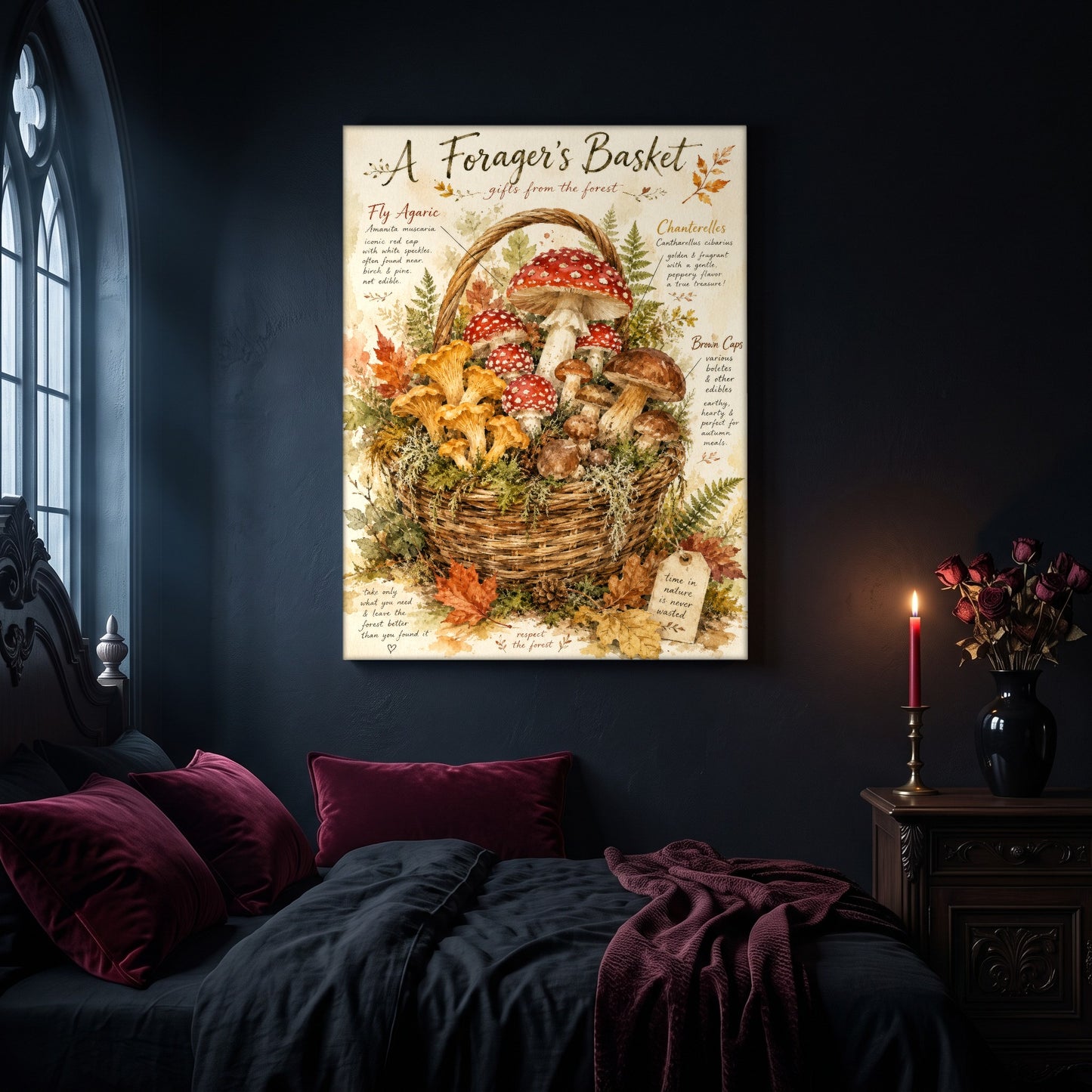 A Forager's Basket canvas hanging on a dark navy wall in a bedroom, above a bed with burgundy velvet pillows and dark bedding, beside an arched leaded window and a nightstand holding a lit red taper candle and a black vase of dried roses.
