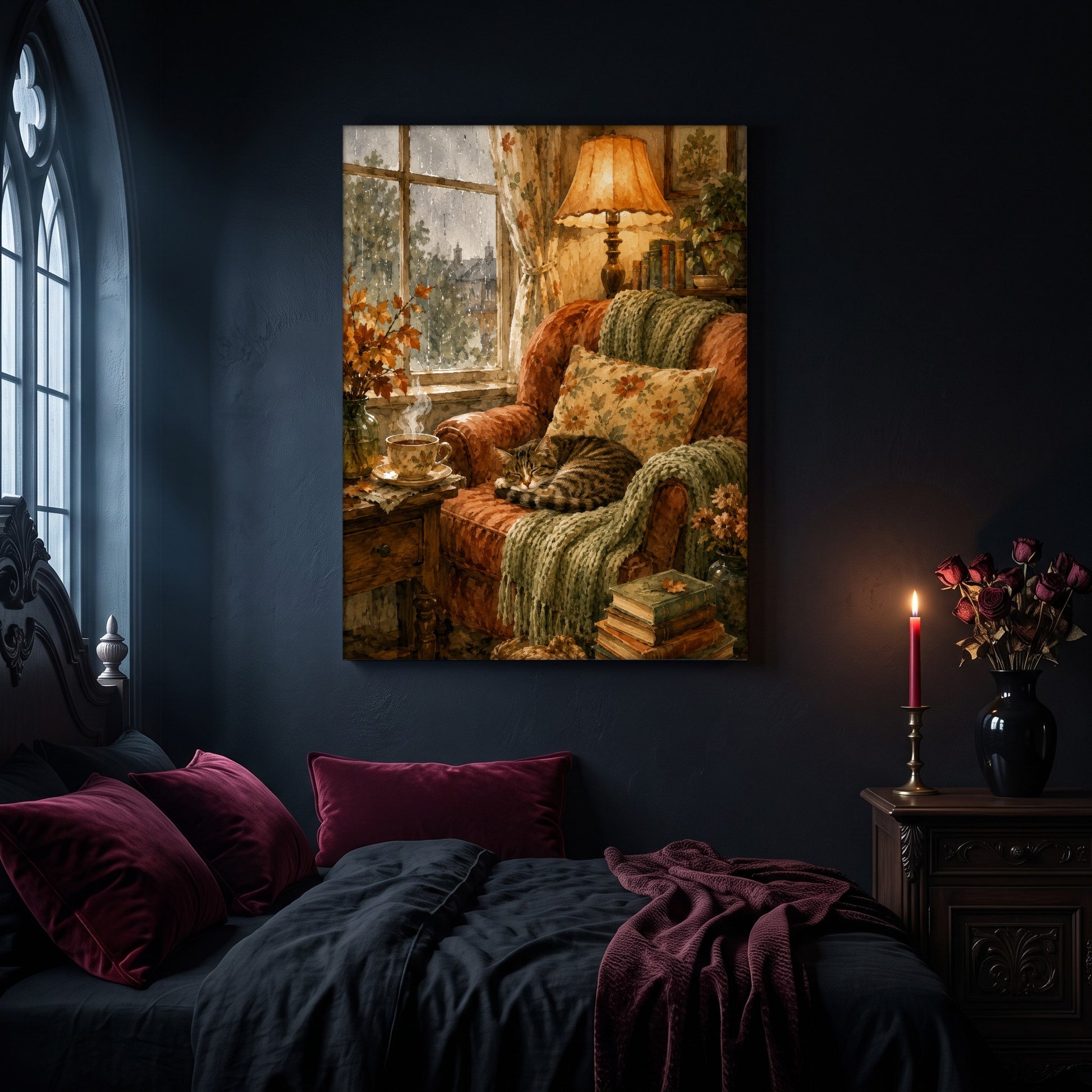 Tabby's Teatime Nap canvas hanging on a dark navy wall in a moody bedroom, above a bed with burgundy velvet pillows and charcoal bedding, beside an arched leaded window and a nightstand holding a lit red taper candle and a vase of dark roses.