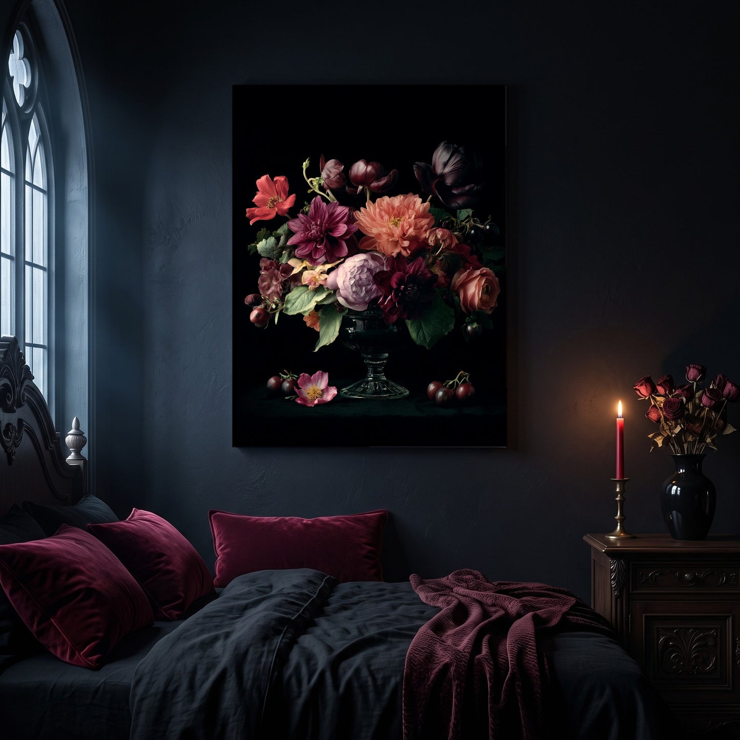 Tazza floral canvas hanging on a dark navy wall in a gothic bedroom, above a bed with burgundy velvet pillows and charcoal bedding, beside an arched leaded window and a wooden nightstand holding a lit red taper candle in a brass holder and a black vase of dried roses.