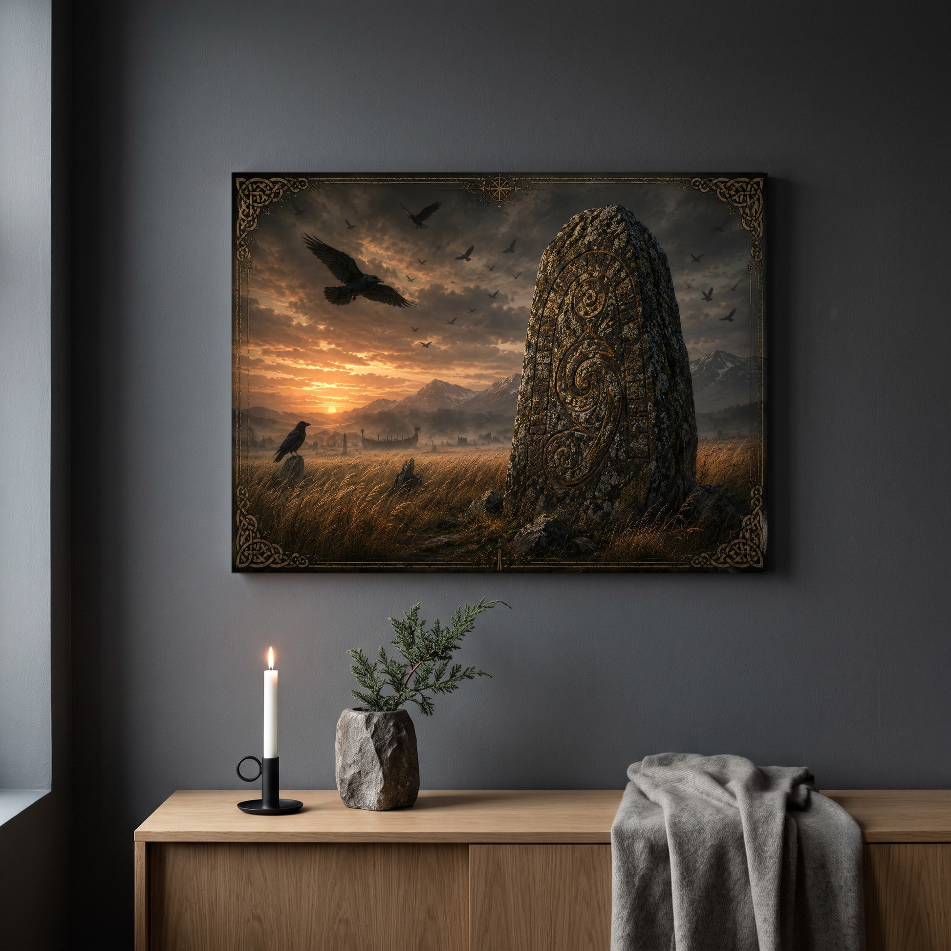 The Harvest Stone runestone print hanging on a plain dark grey wall above a light oak sideboard, styled with a lit white taper candle in a black holder, a stone vase of juniper, and a soft grey throw draped over the end.