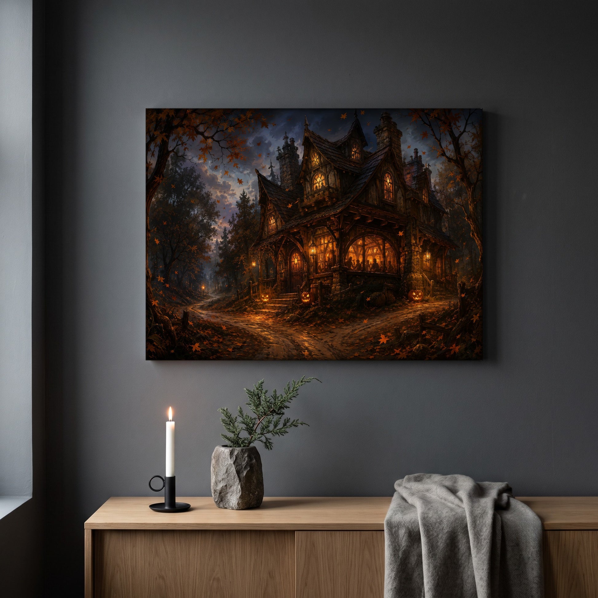  Lantern's End Inn autumn forest print hanging on a plain grey wall above a light oak sideboard, styled with a lit white taper candle in a black holder, a small stone pot of greenery and a folded grey throw.