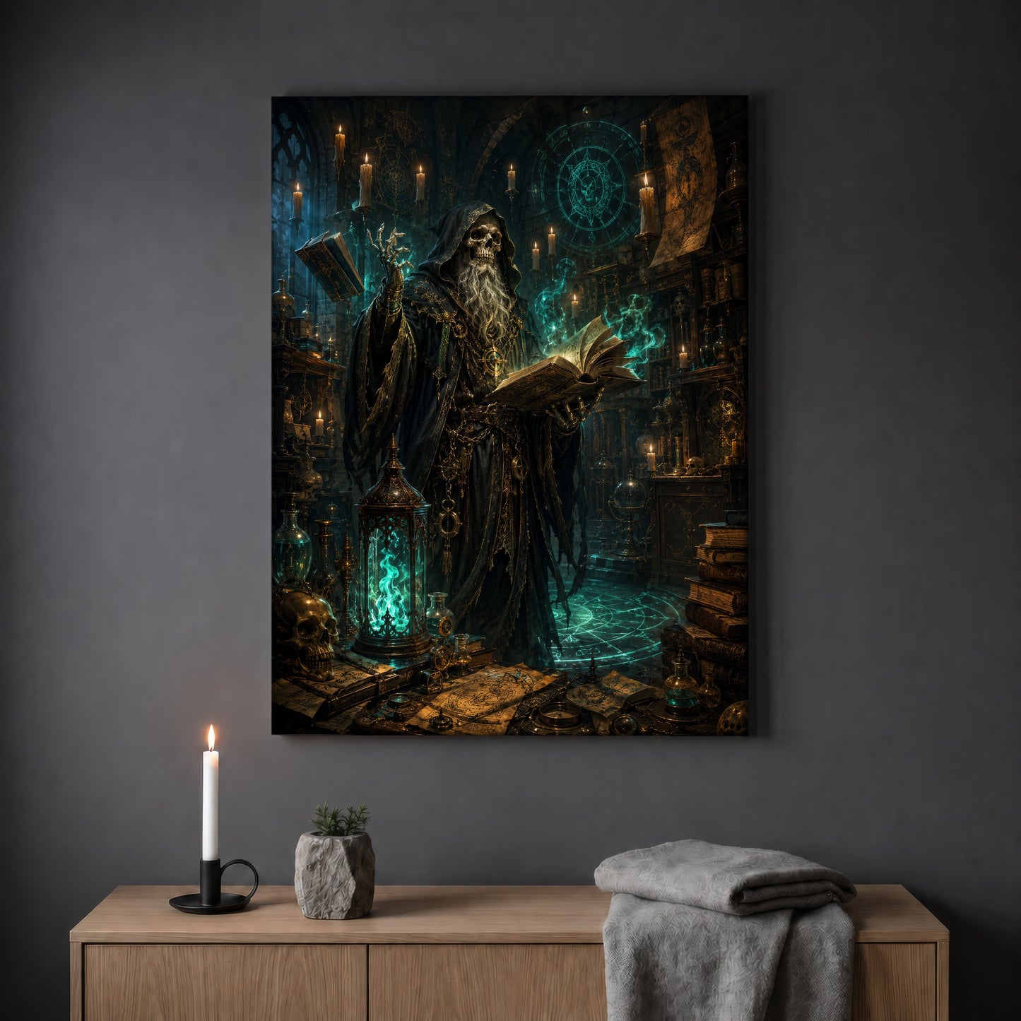 The Hollow Archivist skeletal wizard print hanging on a plain grey wall above a light oak sideboard, styled with a lit white taper candle in a black holder, a small stone pot of greenery and a folded grey throw.