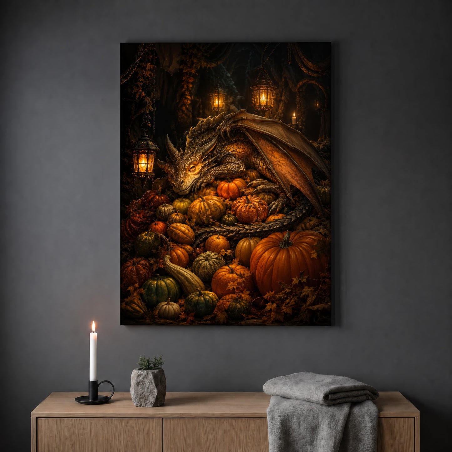 The Pumpkin Den dragon print hanging on a plain grey wall above a light oak sideboard, styled with a lit white taper candle in a black holder, a small stone pot of greenery and a folded grey throw.