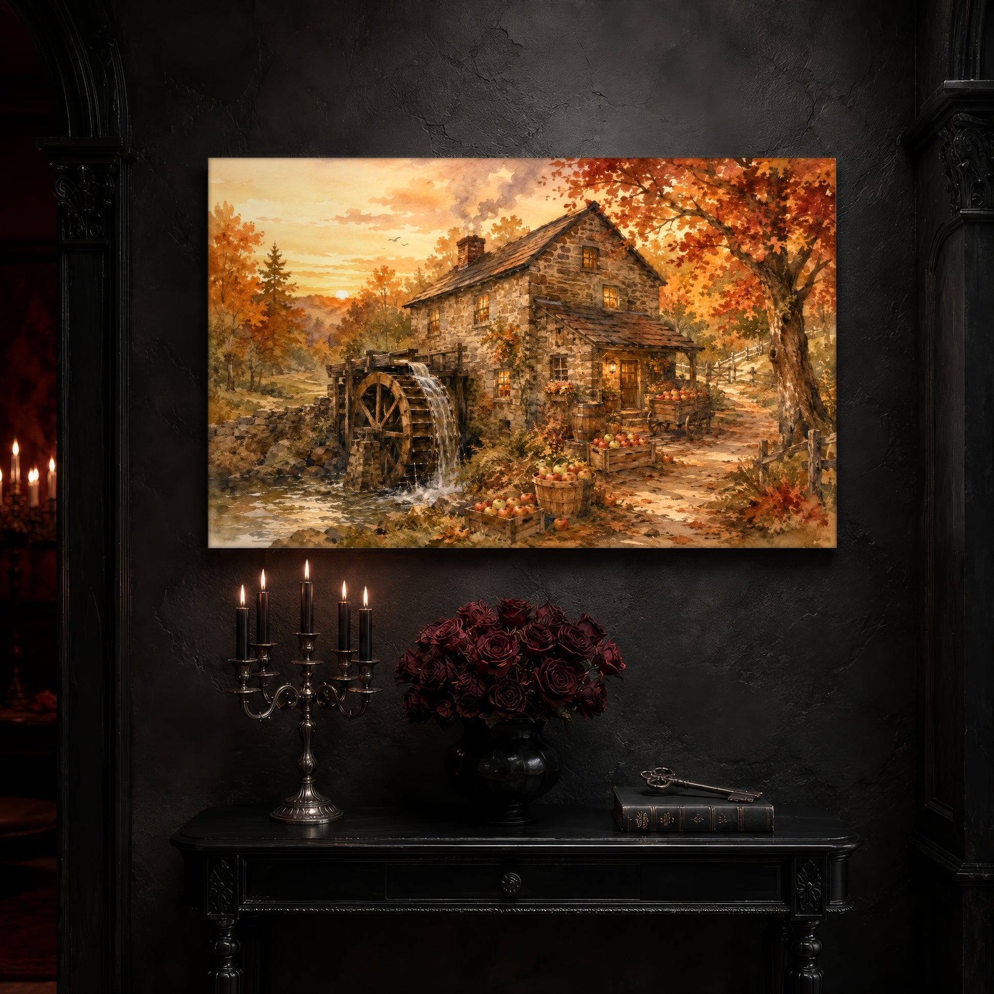 Millpond Gold landscape print on a dark slate stone wall above a black console table, with a five-arm silver candelabra of lit black tapers, an antique iron key resting on a worn leather book, and a black vase of dried roses beside a burgundy velvet curtain.