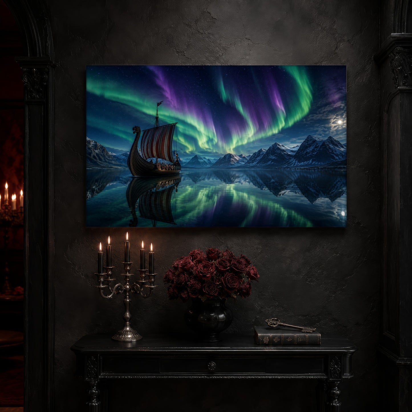 Drakkar longship canvas on a near-black wall above a carved black console table, with a five-arm silver candelabra of lit black tapers, a black vase of deep red roses, and an antique key resting on a leather-bound book.