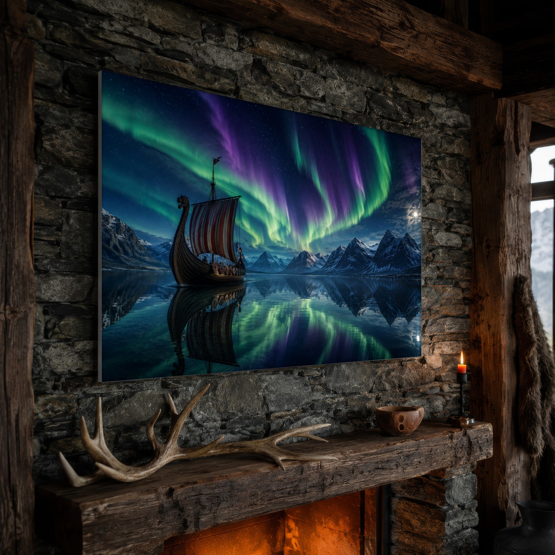  Drakkar wide aurora canvas hanging on a rough stone chimney breast above a rustic timber mantel, with large shed antlers, a carved wooden bowl and a lit red candle along the beam, firelight glowing from the hearth below and a mountain window to the right.