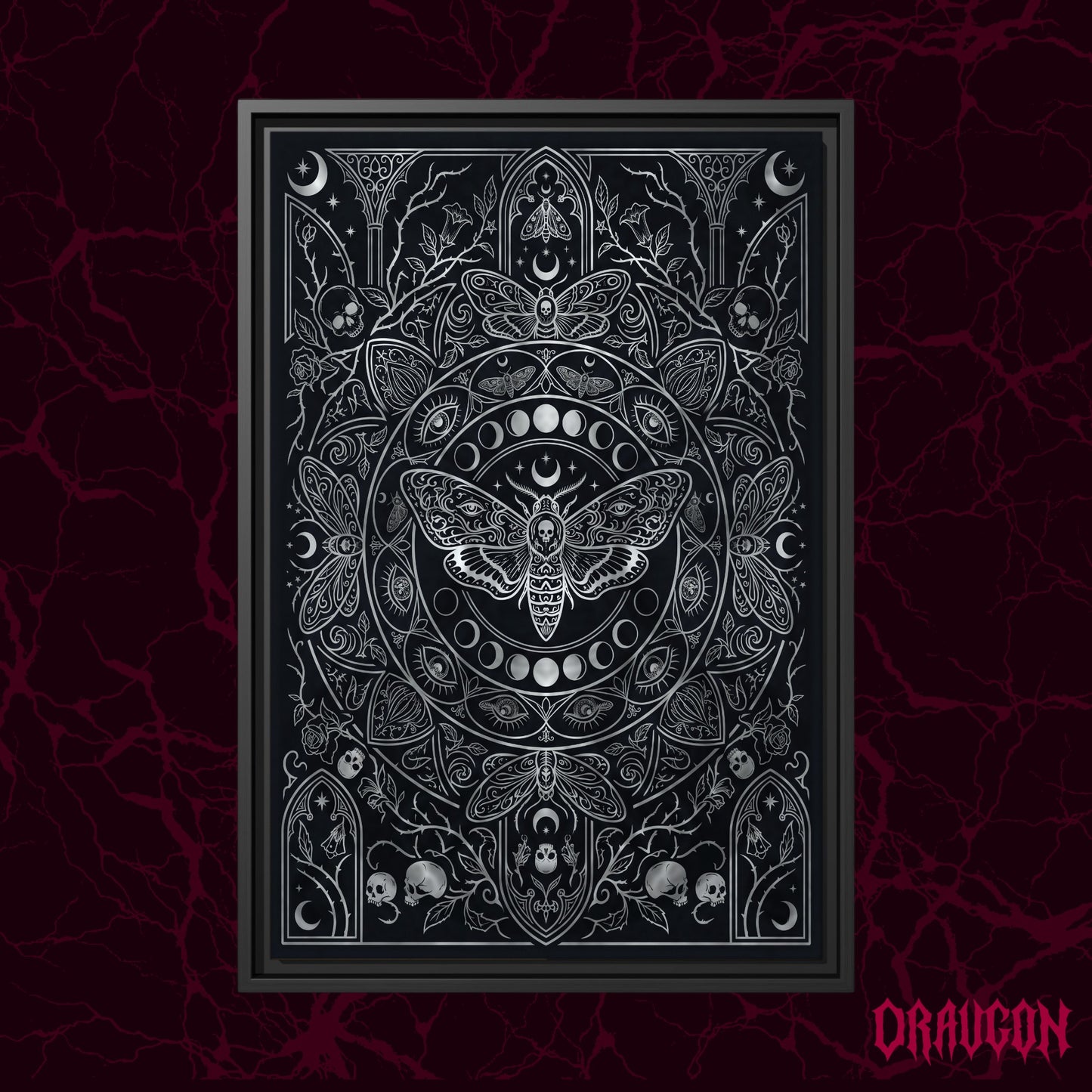 Vanitas shown as a black framed canvas against a deep red marbled backdrop with the Draugon wordmark in the lower corner, displaying the full silver death moth and moon phase engraving.
