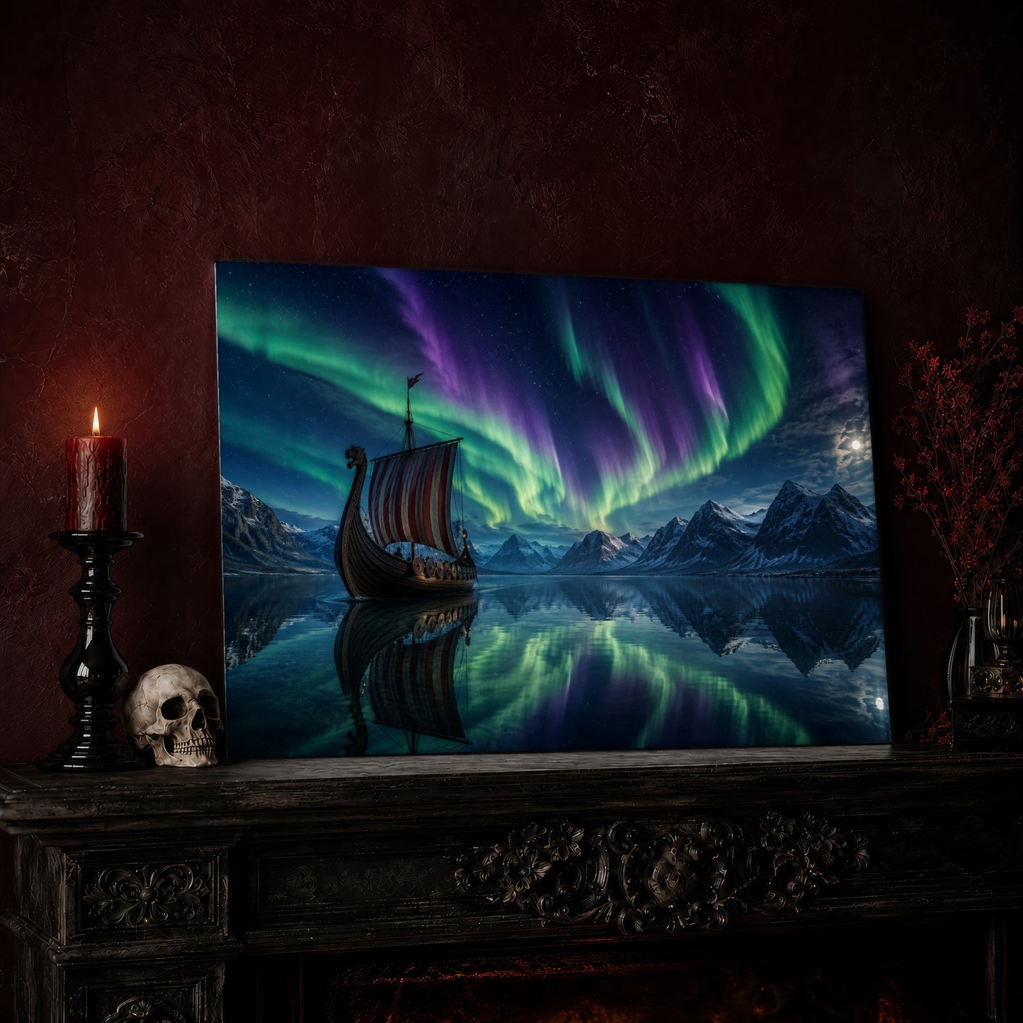 Drakkar print leaning on a dark carved mantel against an oxblood wall, beside a lit dark red pillar candle in a black candlestick, a bone-coloured skull, and a vase of red berry sprigs with a brass lantern to the right.