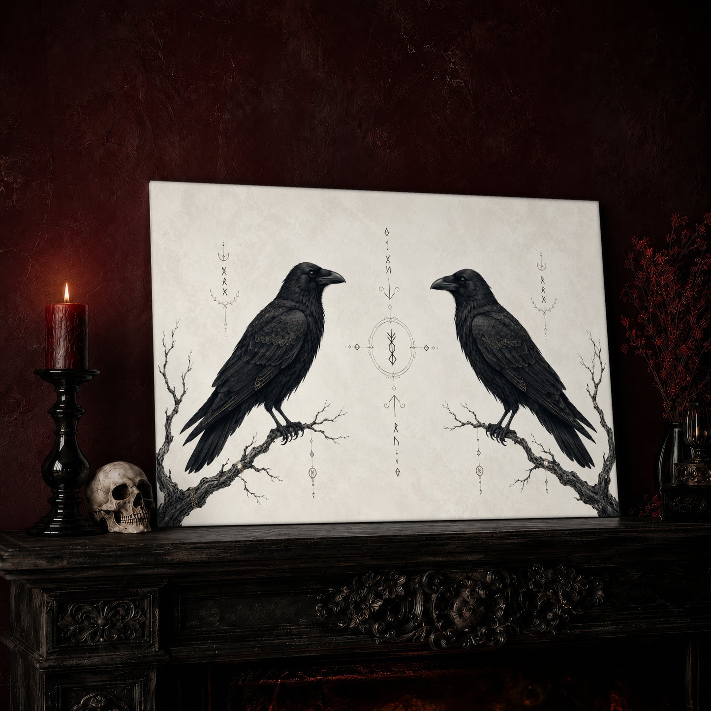 Huginn & Muninn print leaning on a dark carved mantel against an oxblood wall, beside a lit dark red pillar candle in a black candlestick, a bone-coloured skull, and a vase of red berry sprigs with a brass lantern to the right.