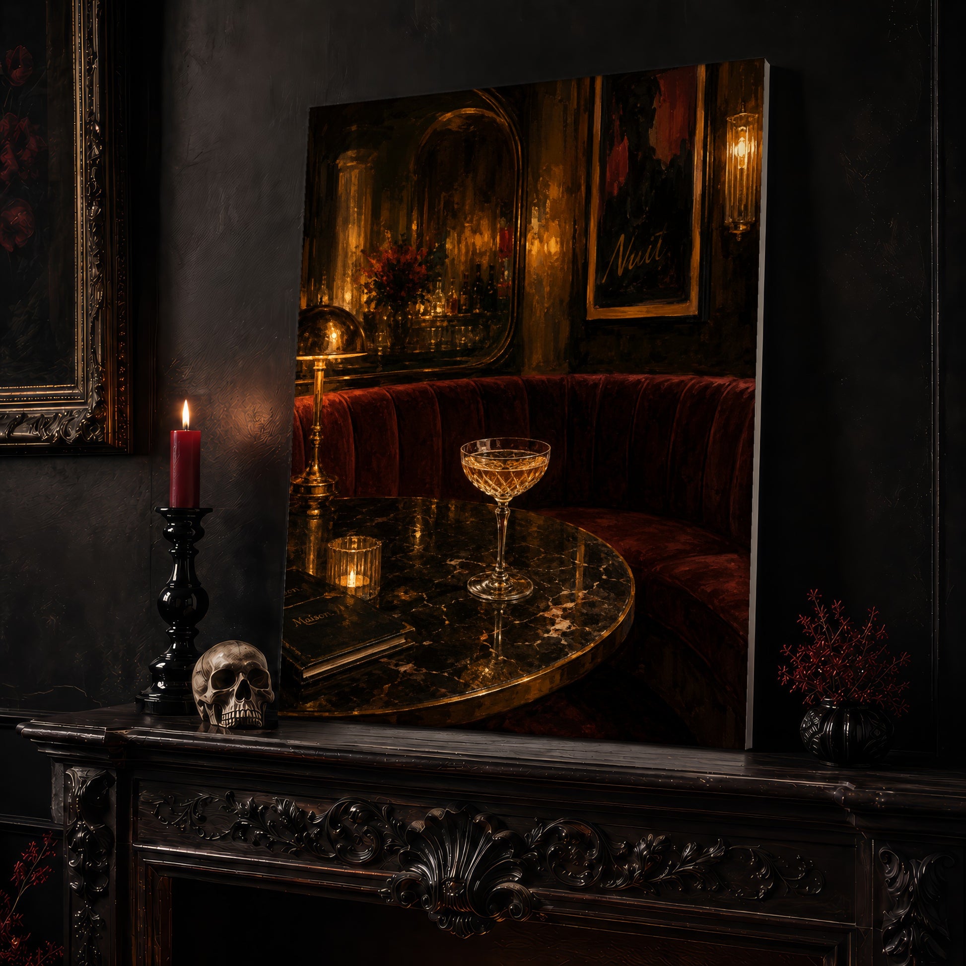 Nuit canvas leaning on a dark carved mantel beside a lit dark red taper in a black candlestick, a bone-coloured skull, and a small black vase of red berry sprigs, with a gilt-framed painting on the wall alongside.