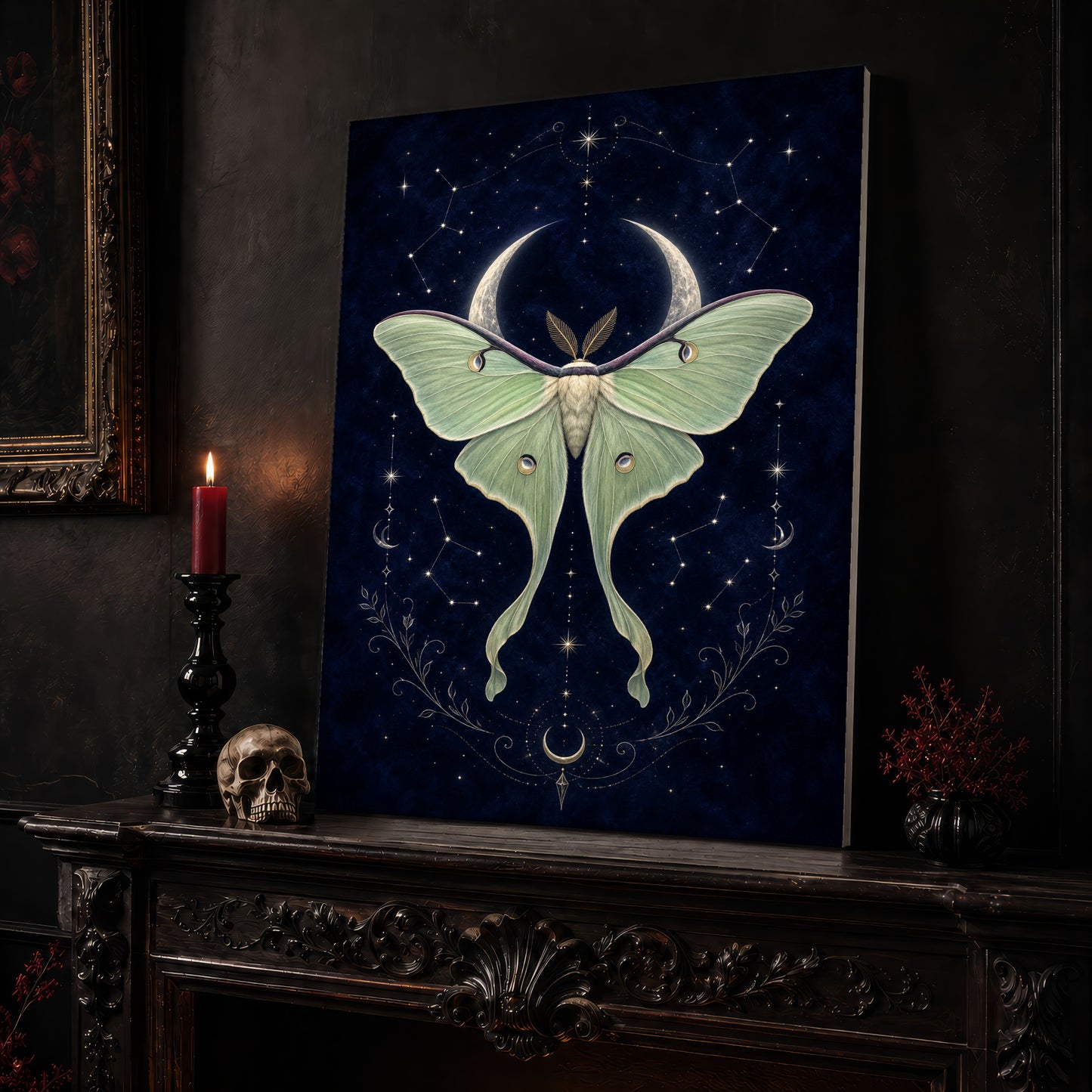 Verdigris luna moth canvas leaning on a dark carved mantel beside a lit dark red taper in a black candlestick, a bone-coloured skull, and a small black vase of red berry sprigs, with a gilt-framed painting on the wall alongside.