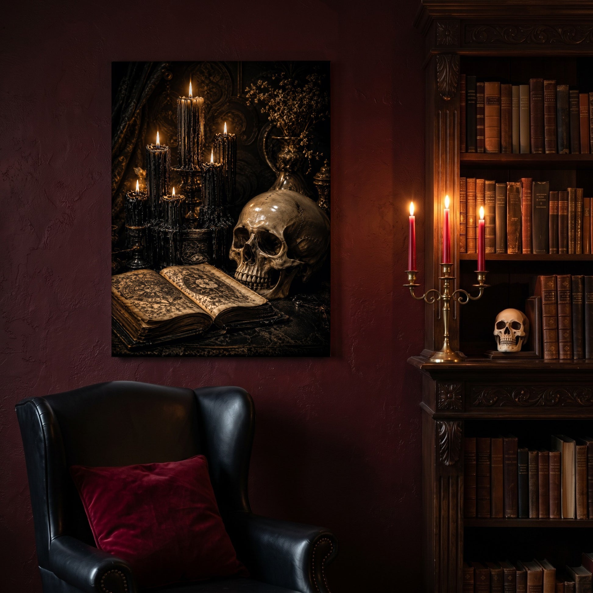 The Black Hours canvas hanging on a deep oxblood wall in a reading nook, above a black leather wingback chair with a red velvet cushion, beside a carved bookcase of antique books, a brass candelabra of lit red tapers and a human skull on the shelf.