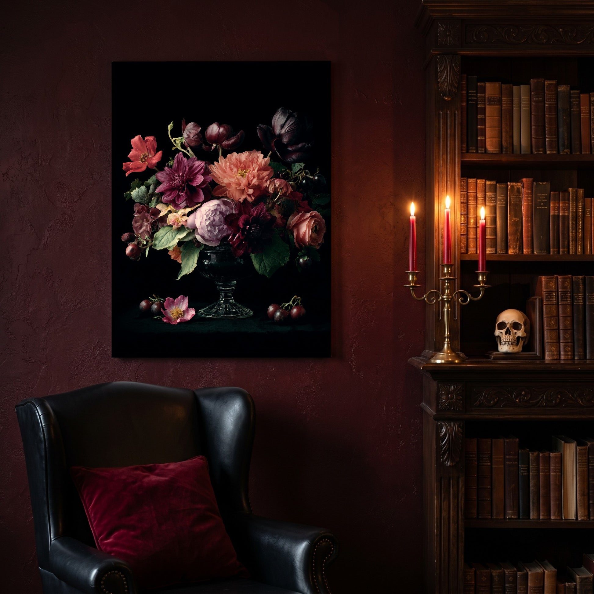 Tazza floral canvas hanging on a deep oxblood wall in a reading nook, above a black leather wingback chair with a red velvet cushion, beside a carved bookcase of antique books, a brass candelabra of lit red tapers and a human skull on the shelf.

