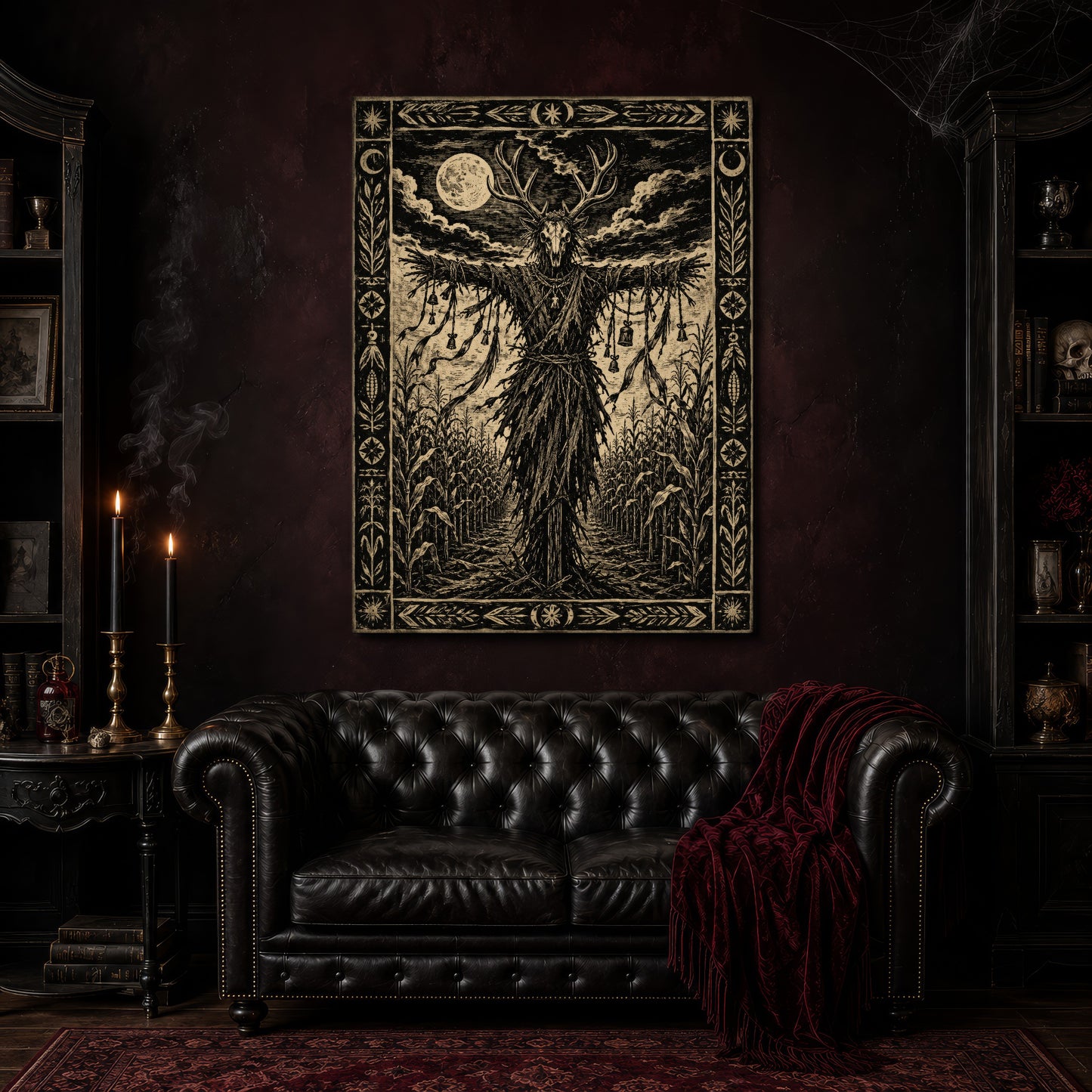 The Corn Sentinel canvas hanging above a black tufted Chesterfield loveseat draped with a red fringed velvet throw, in a cobwebbed oxblood parlour with brass candlesticks, dark bookshelves and a patterned red rug.