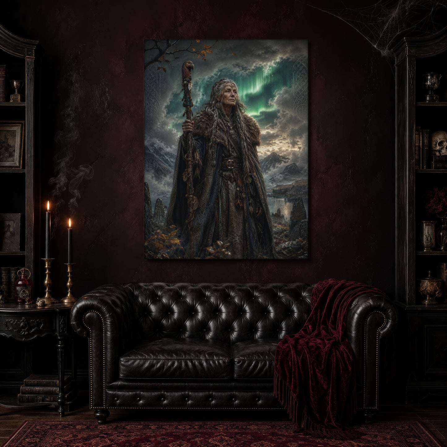 Spákona canvas hanging above a black tufted Chesterfield sofa draped with a red fringed velvet throw, in a cobwebbed oxblood parlour with brass candlesticks, dark cabinets of books and goblets, and a patterned red rug.