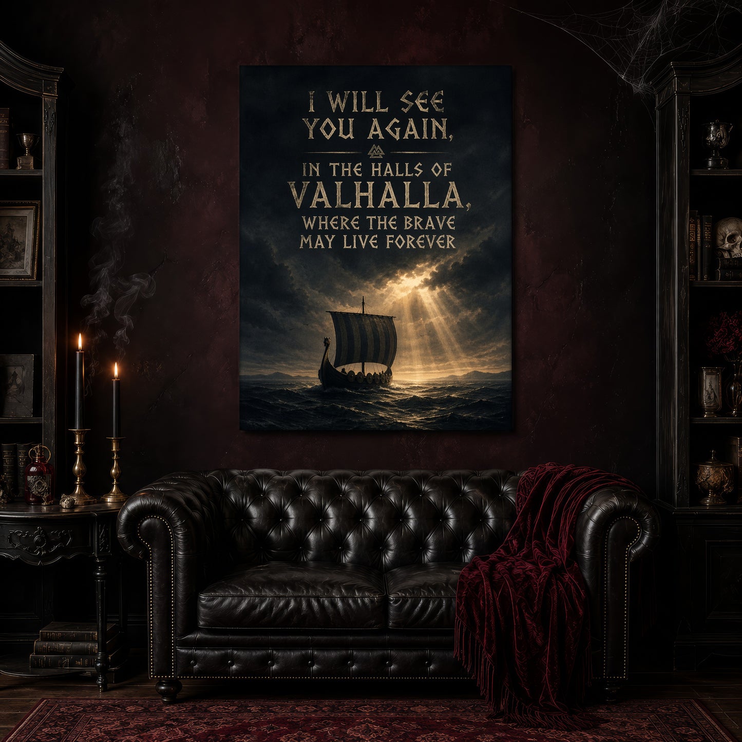 Valhalla Awaits canvas hanging above a black tufted Chesterfield sofa draped with a red fringed velvet throw, in a cobwebbed oxblood parlour with brass candlesticks, dark cabinets of books and goblets, and a patterned red rug.

